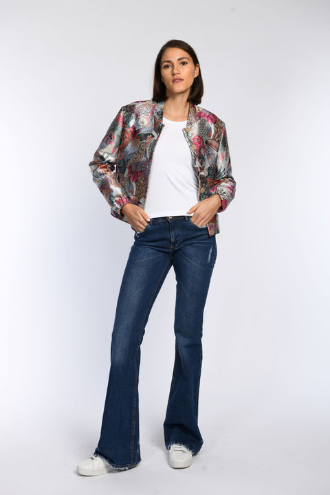 Model trägt locker geschnittenes Blouson mit zartem Glanz und Vogelmuster, kombiniert mit weißem Shirt und Jeans.