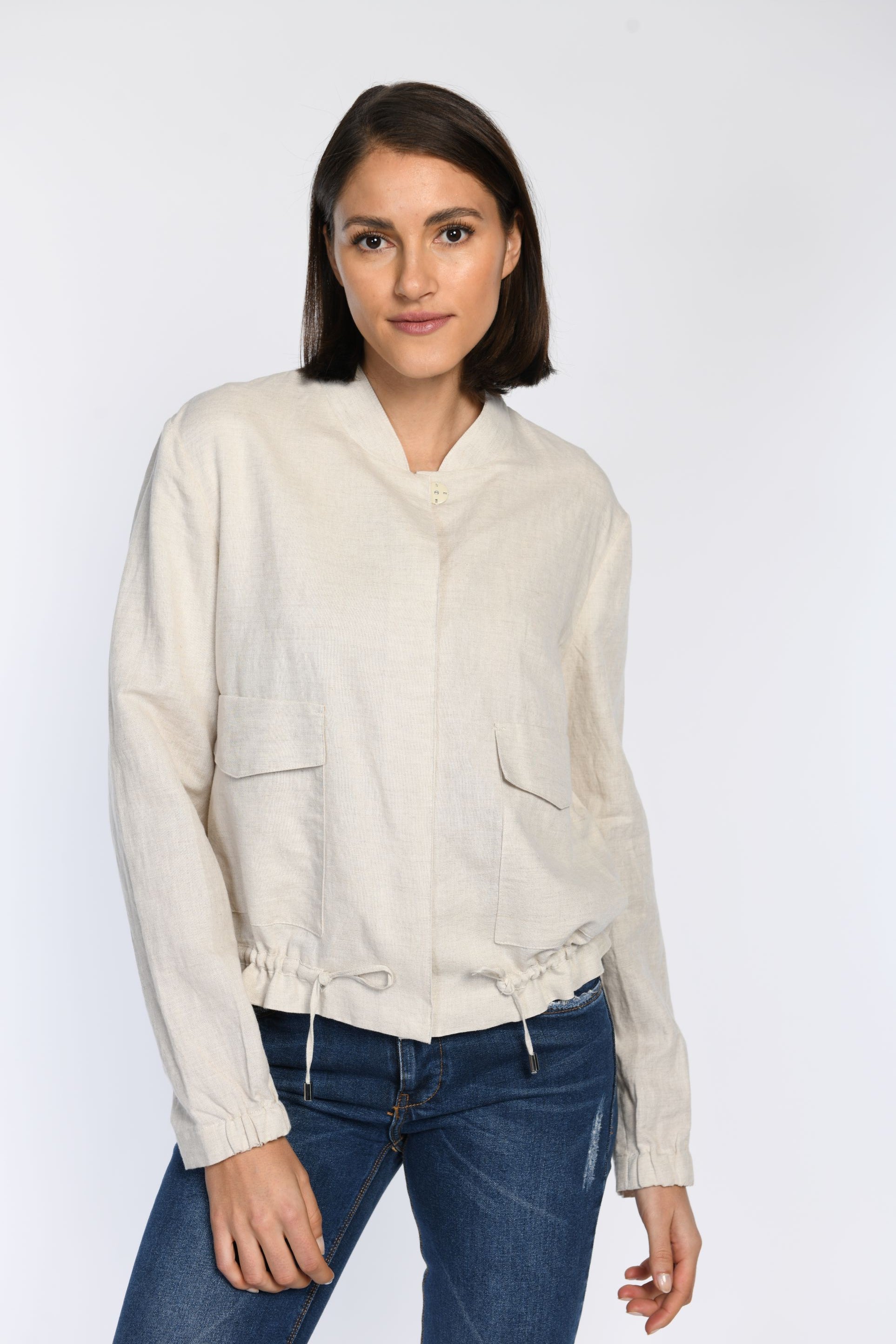 Model trägt ein geschlossenes Leinen-Blouson mit aufgesetzten Taschen und Tunnelzug am Saum zur Weitenregulierung.