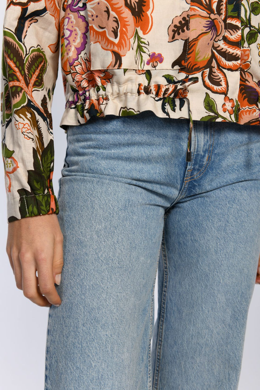 Detail: Tunnelzug am Saum zur Weitenregulierung am Leinen-Blouson mit Floraldruck. 