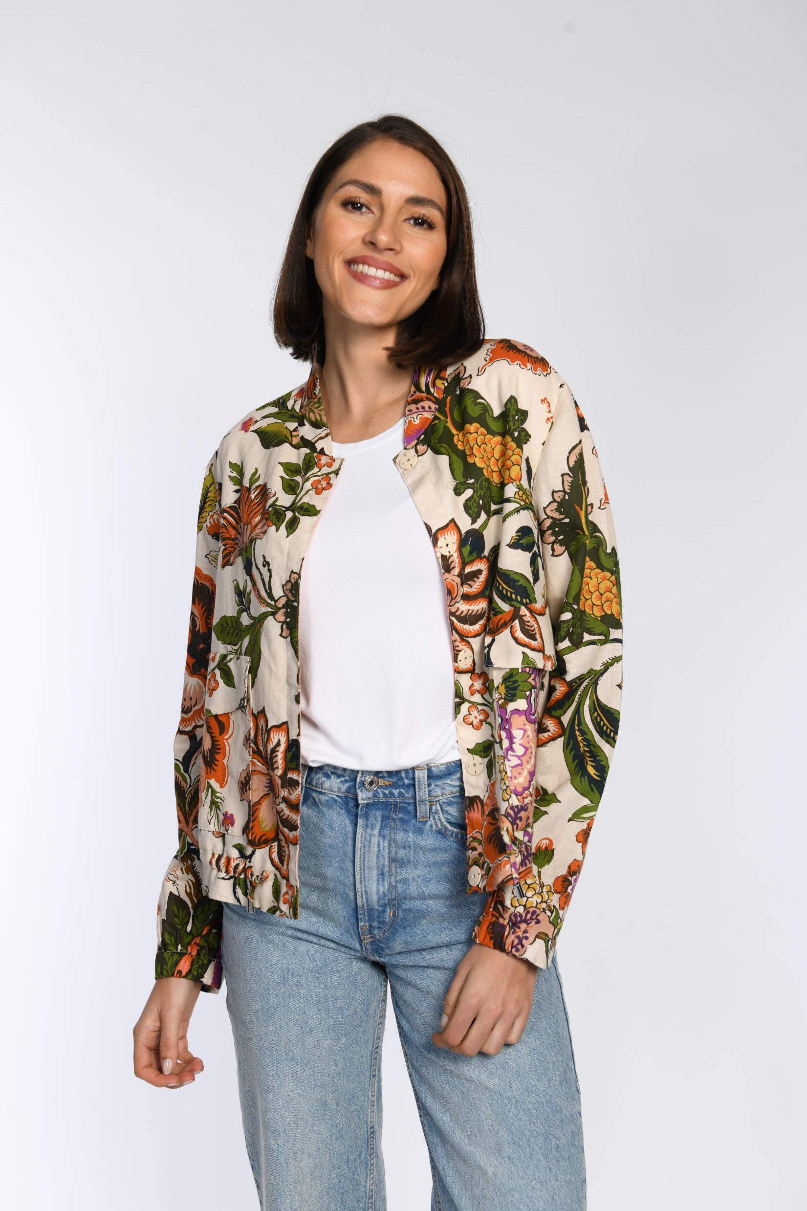 Model trägt einen sommerlichen Blouson mit Floraldruck und Druckknopfverschluss. 