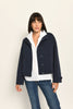 Model trägt dunkelblauen Blouson für Damen aus Scuba, lässig kombiniert zu einer weißen Bluse – Vorderseite