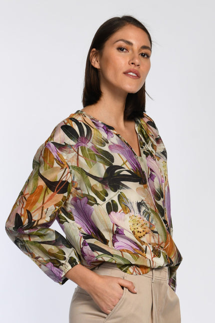 Model trägt leichte Bluse mit floralem Druck und 3/4-Ärmeln.
