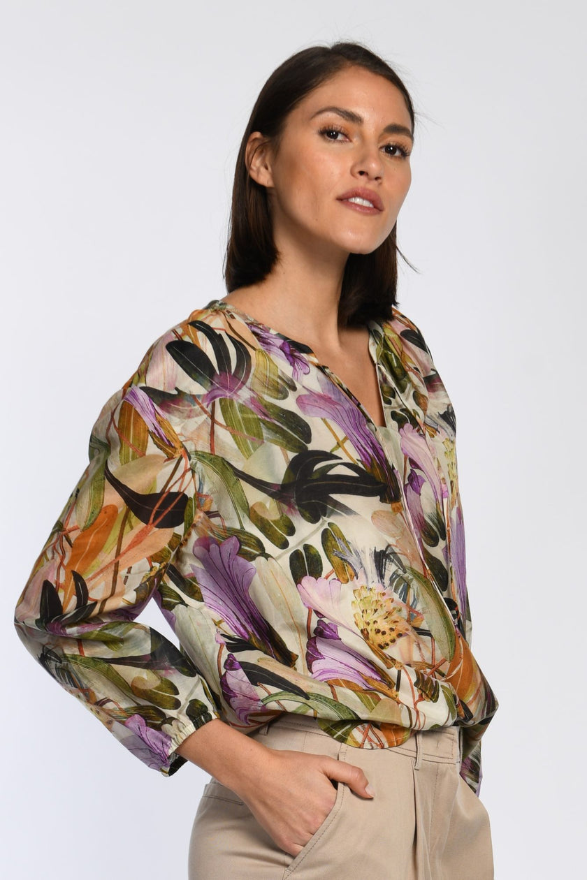 Model trägt leichte Bluse mit floralem Druck und 3/4-Ärmeln.