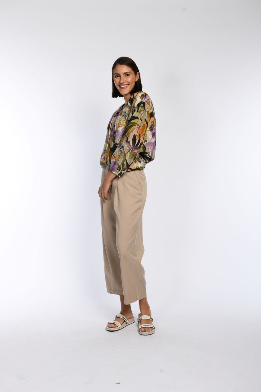 Model präsentiert leichte Bluse mit floralem Druck und Rundhalsausschnitt mit Bindebändern.