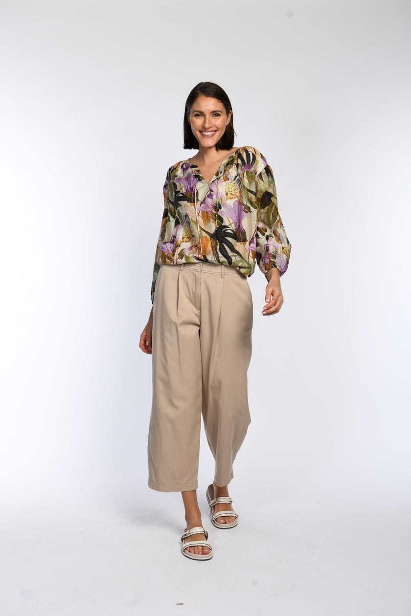 Vorderansicht: Model trägt eine leicht fallende Bluse mit floralem Druck.
