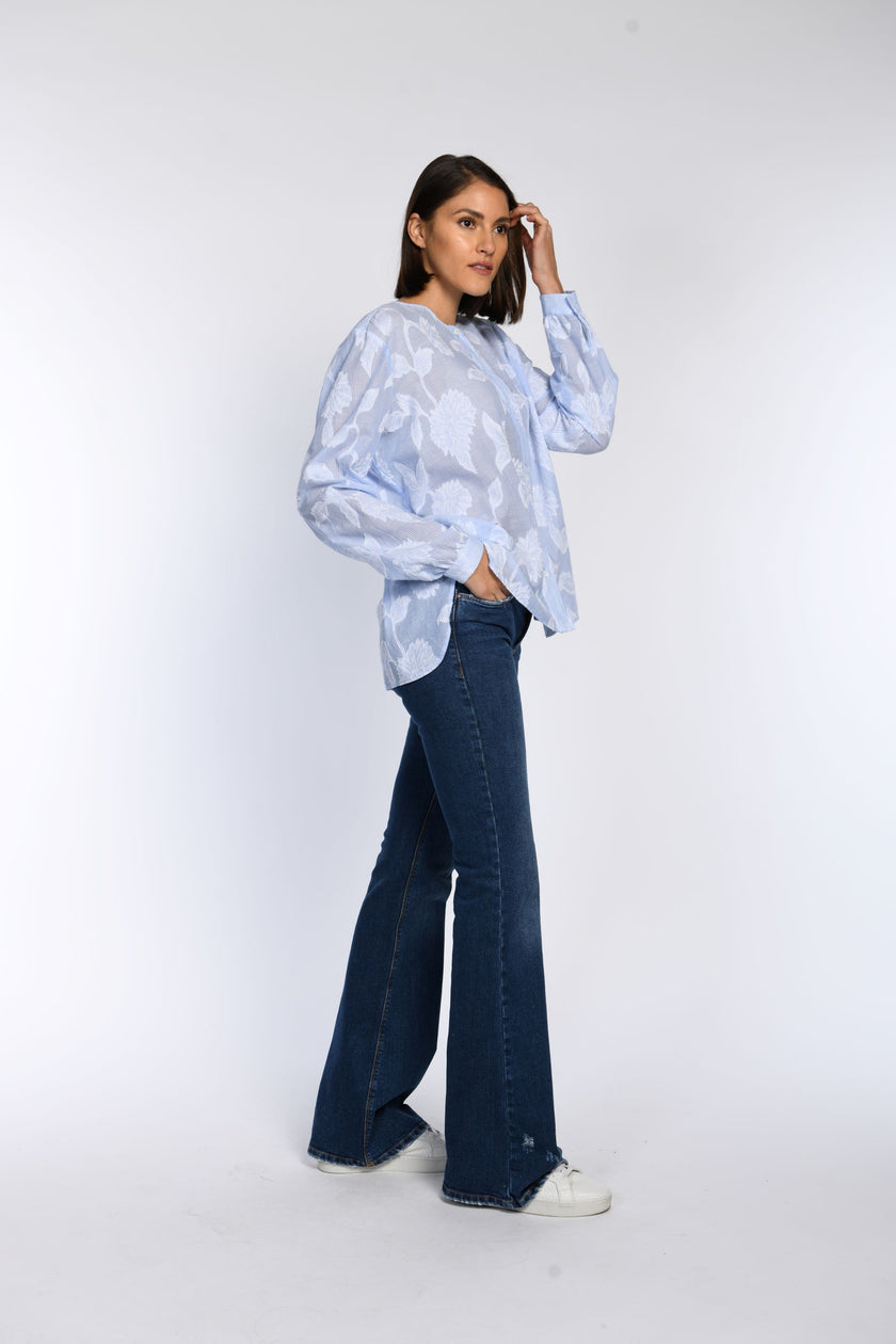 Model trägt locker geschnittene Baumwollbluse mit feinen Streifen. 