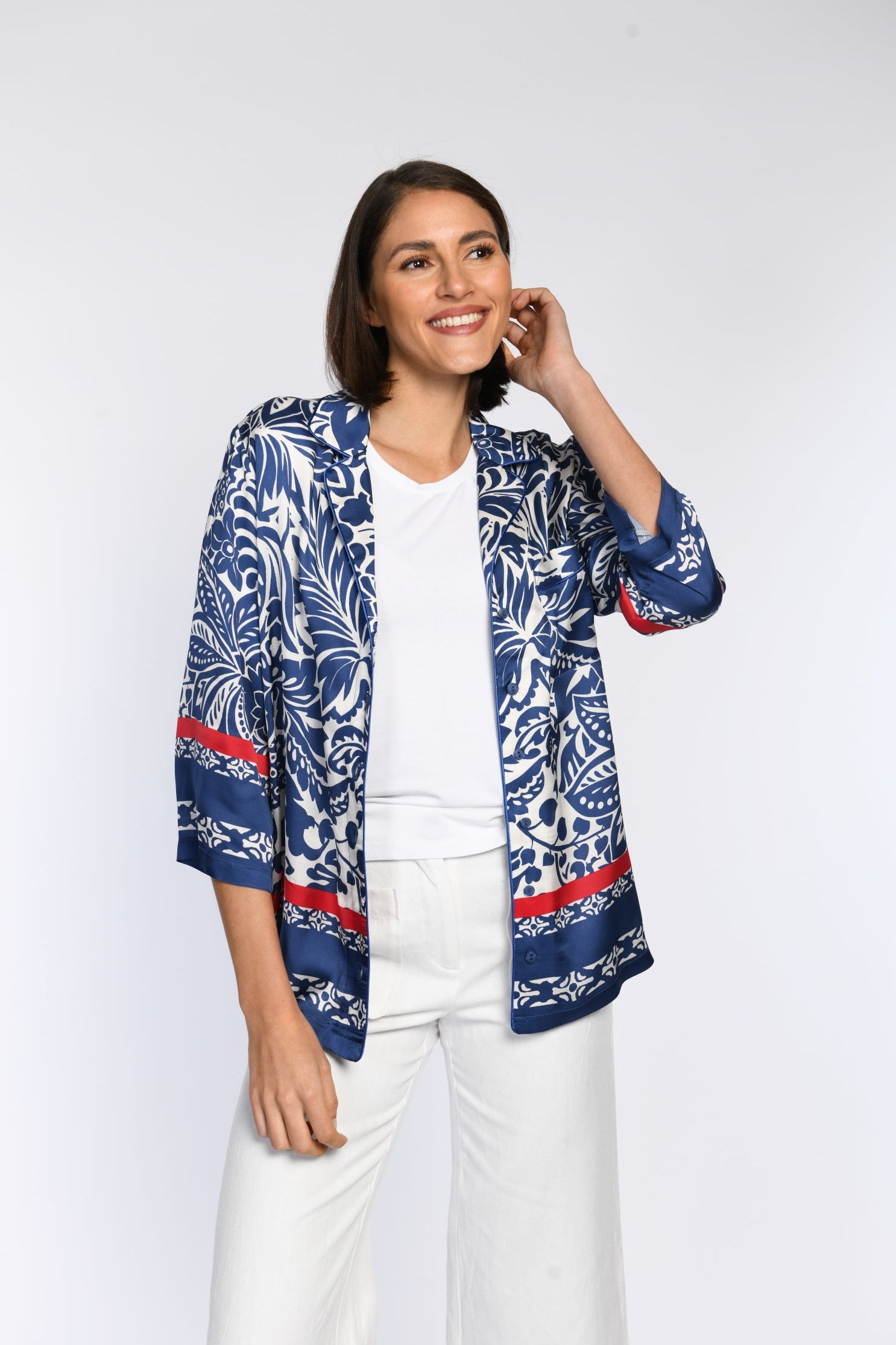 Vorderansicht einer offen getragenen, blau bedruckten Bluse mit roten Akzenten.