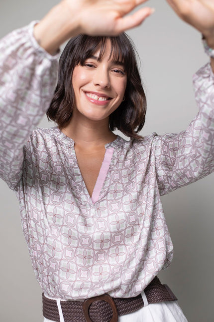 Helle Tunikabluse mit Pastelldruck, einem V-Ausschnitt mit dekorativem rosa Band und elastischem Ärmelsaum.