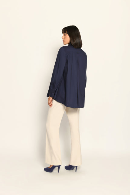 Moderne, weit geschnittene marineblaue Damenbluse mit langen Ärmeln, lässig kombiniert zu beiger Hose – Rückseite