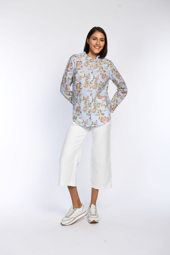 Model trägt Bluse mit Streifen- und Floraldruck, abgerundetem Saum und Knopfleiste vorne.