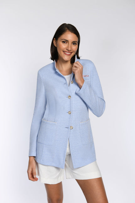 Model trägt blaufarbigen Gehrock mit Stehkragen und aufgesetzten Taschen unterhalb der Taille.