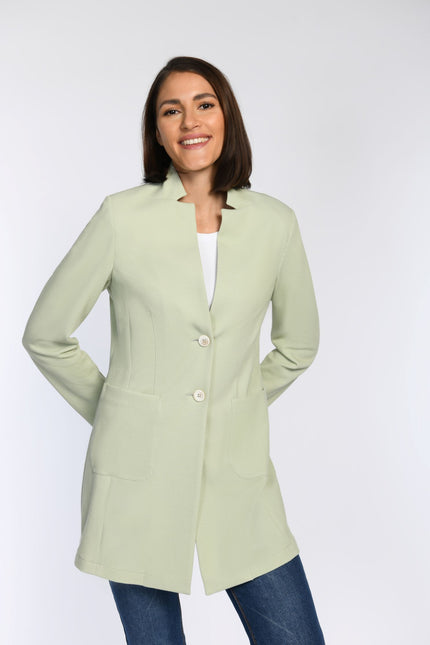 Model in pastellgrünem Gehrock mit stehendem Revers und Taschen.