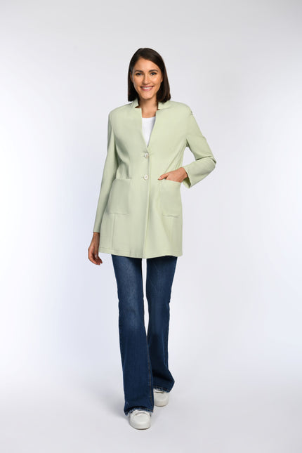 Model trägt einen figurbetonten Gehrock in Pastellgrün.