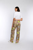 Model trägt eine weite Palazzo-Hose mit geradem Bein und buntem Druck - Rückenansicht.