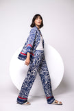 Model trägt eine Kombination aus weiter Palazzo-Hose und Bluse im Pyjama-Look.
