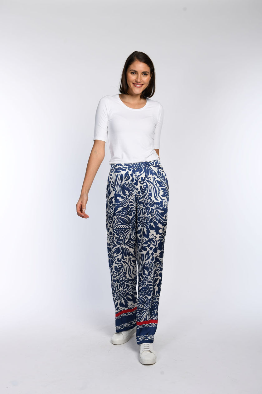 Model trägt eine weite Hose aus bedrucktem Viskosesatin mit geradem Bein.