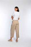 Verkürzte beige Hose mit weitem Bein, Gürtelschlaufen und Leistentaschen im Rückteil.