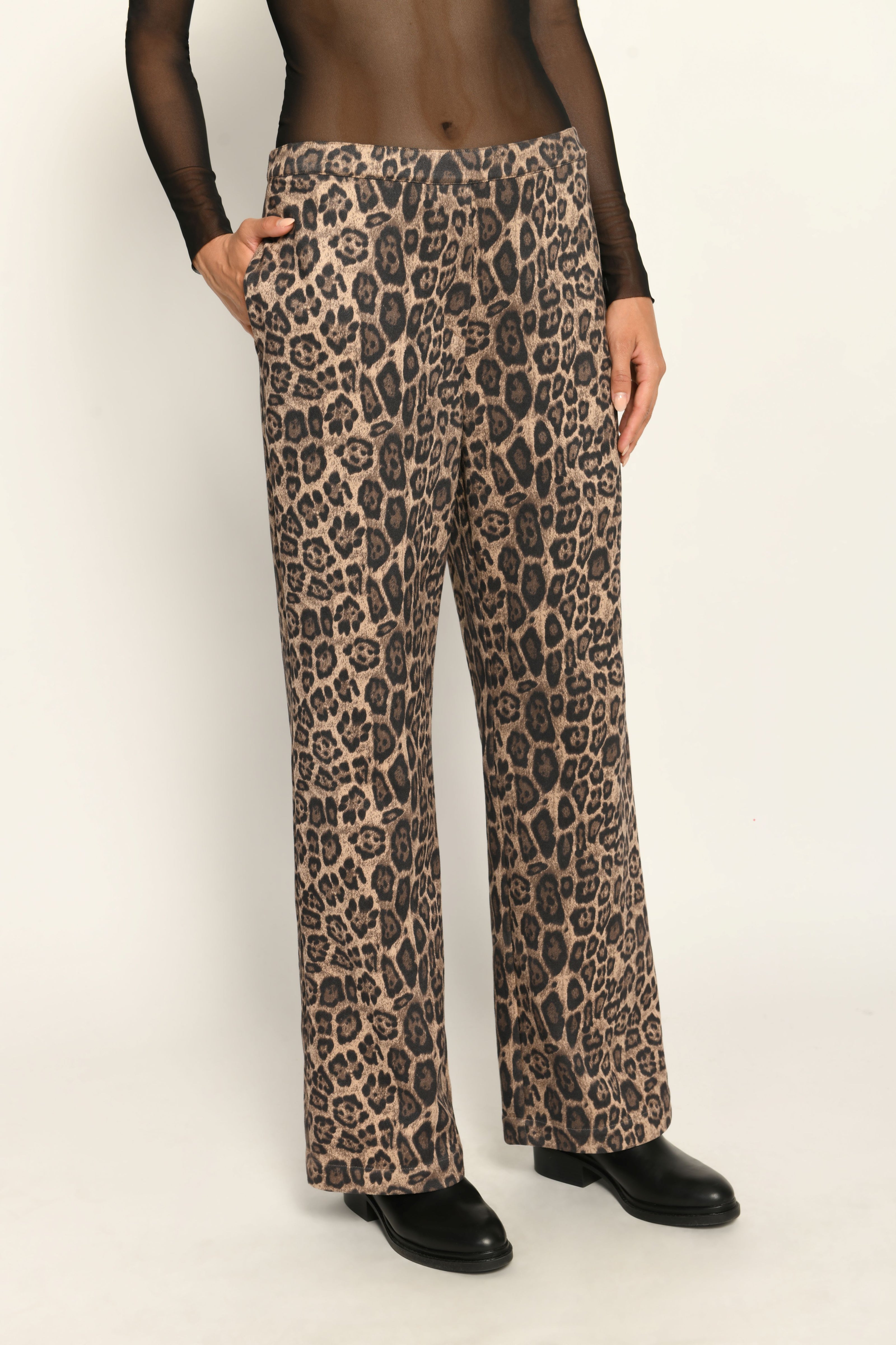 Lange Hose aus Scuba im Leo-Dessin für Damen, lässig kombiniert mit schwarzem transparentem Oberteil – Vorderansicht.