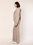 Model trägt eine  lässig sitzende Cord Hose aus Baumwoll Jersey in der Farbe Beige  - Seitenansicht.