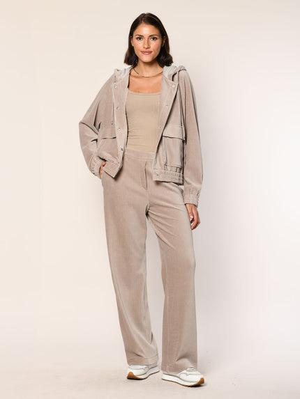 Model trägt eine  lässig sitzende Cord Hose aus Baumwoll Jersey in der Farbe Beige  - Vorderansicht.