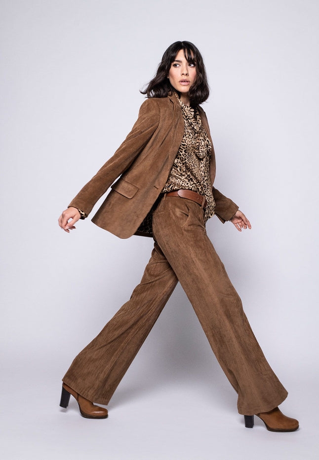 Model trägt Hosenanzug für Damen aus braunem Cord, bestehend aus lässigem Blazer und softer, gerader Hose.