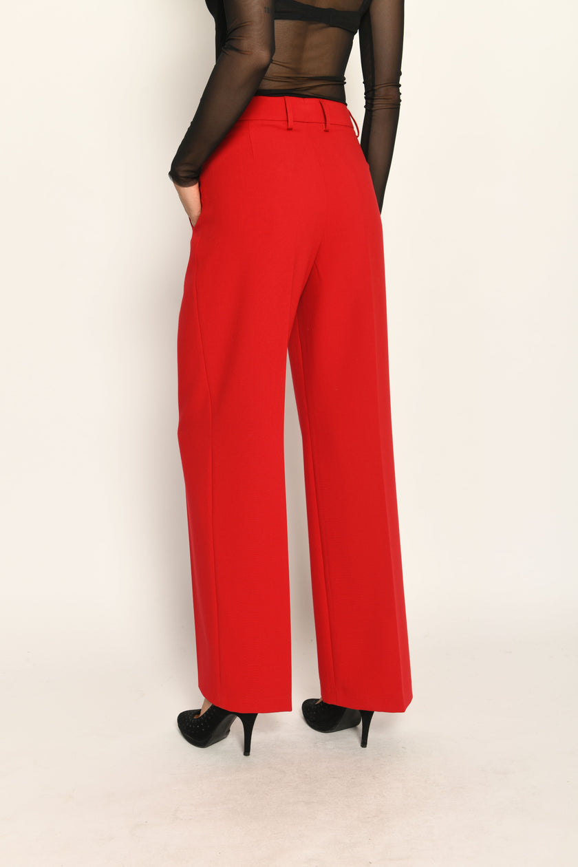 Lange Anzughose für Damen in der Farbe Rot, lässig kombiniert mit schwarzem transparentem Oberteil – Rückansicht.