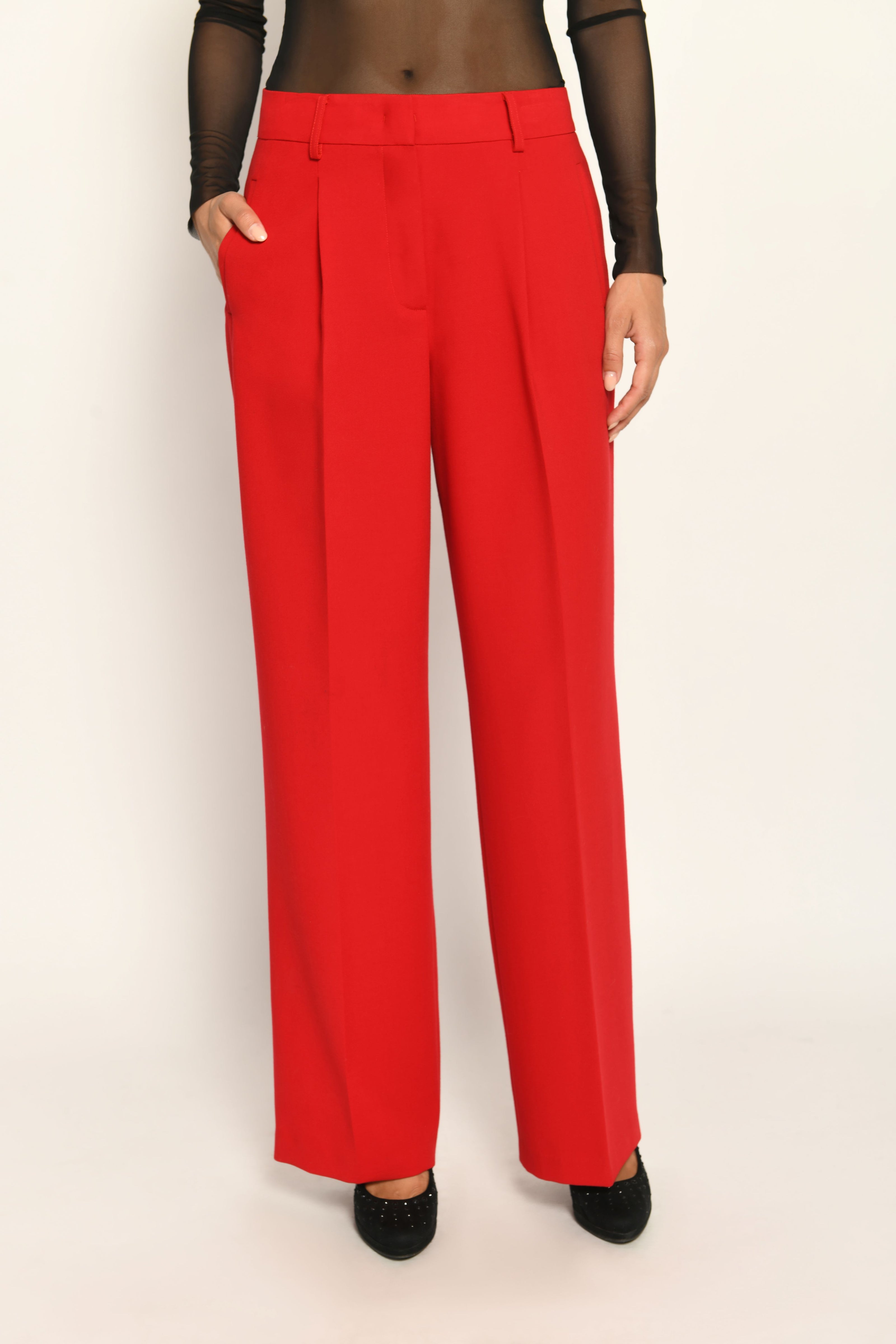 Lange Anzughose für Damen in der Farbe Rot, lässig kombiniert mit schwarzem transparentem Oberteil – Vorderseite.