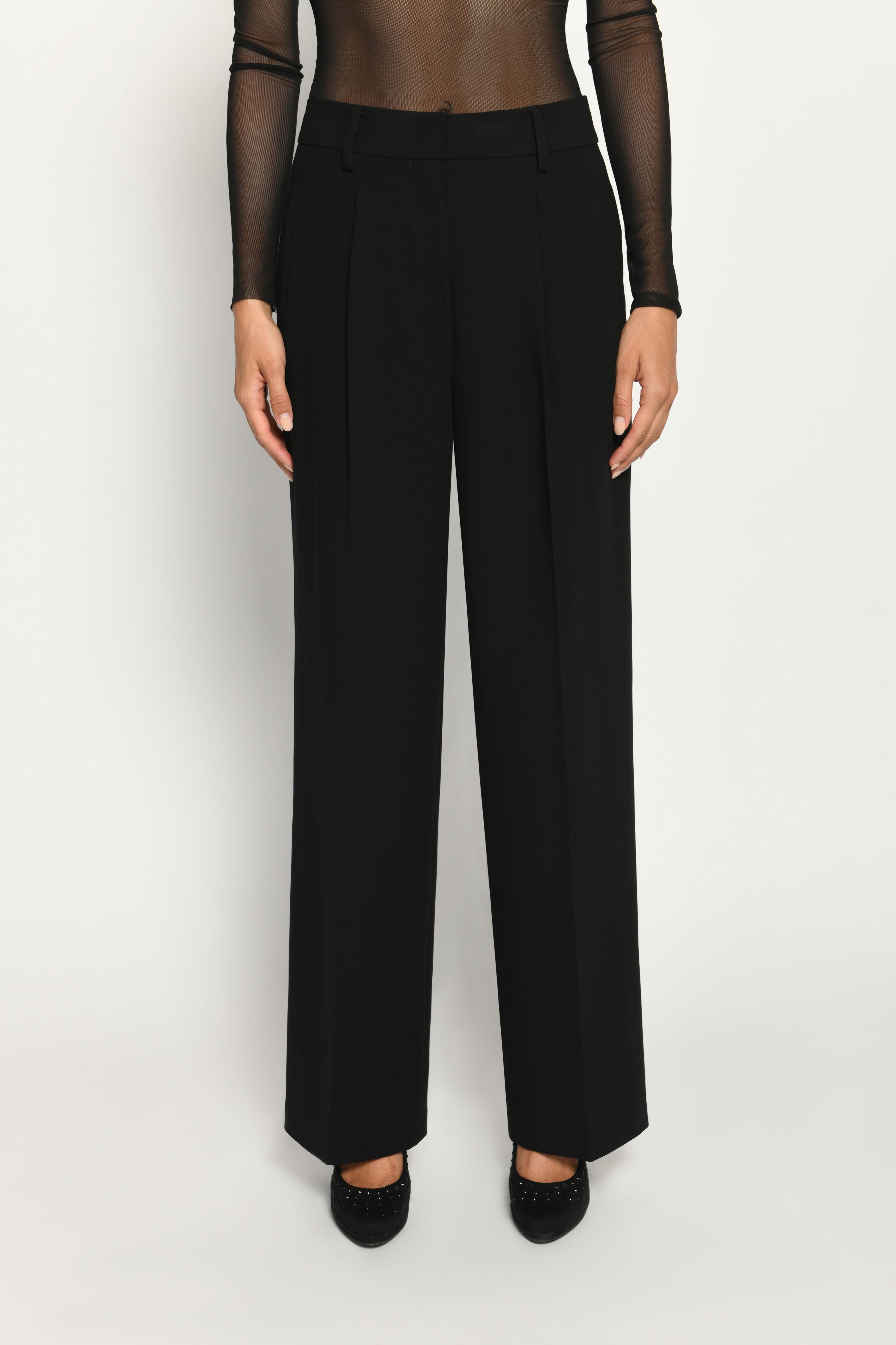 Lange Anzughose für Damen in der Farbe Schwarz, lässig kombiniert mit schwarzem transparentem Oberteil – Vorderansicht.