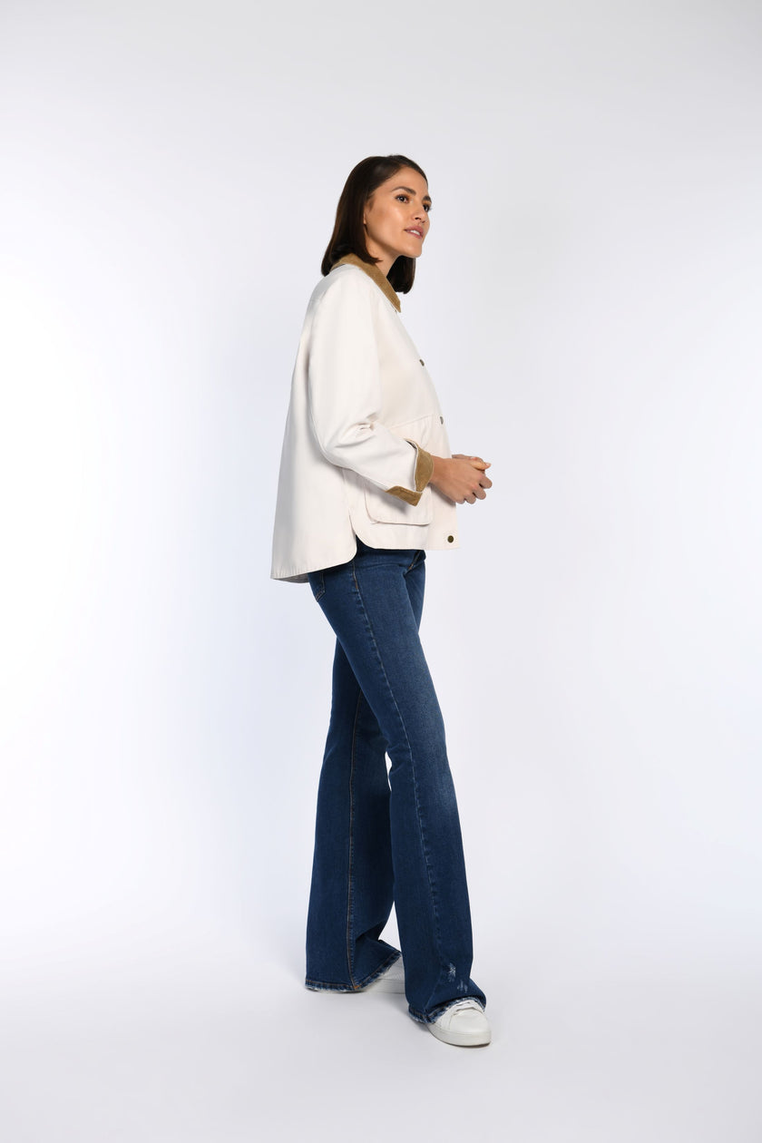 Model trägt cremefarbene Jacke mit Cord-Details und Taschen, Rückteil länger als Vorderteil.