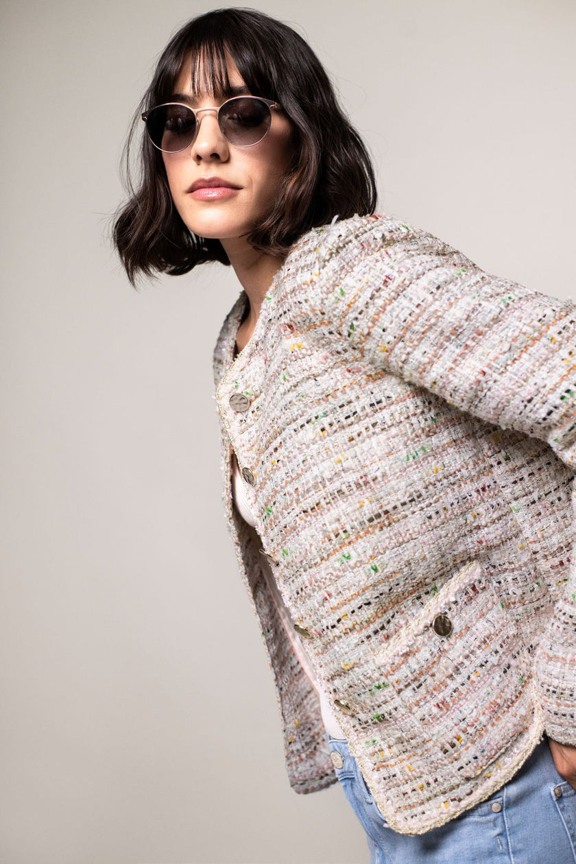 Detailaufnahme der sommerlichen Boucléjacke in Pastellfarben mit aufgesetzten Taschen.