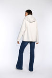 Rückenansicht eines Models in einer cremefarbenen Cabanjacke mit Kapuze.
