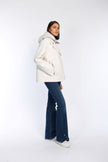 Seitenansicht einer cremefarbenen Caban-Jacke mit Kapuze an einem Model kombiniert mit einer Jeans.