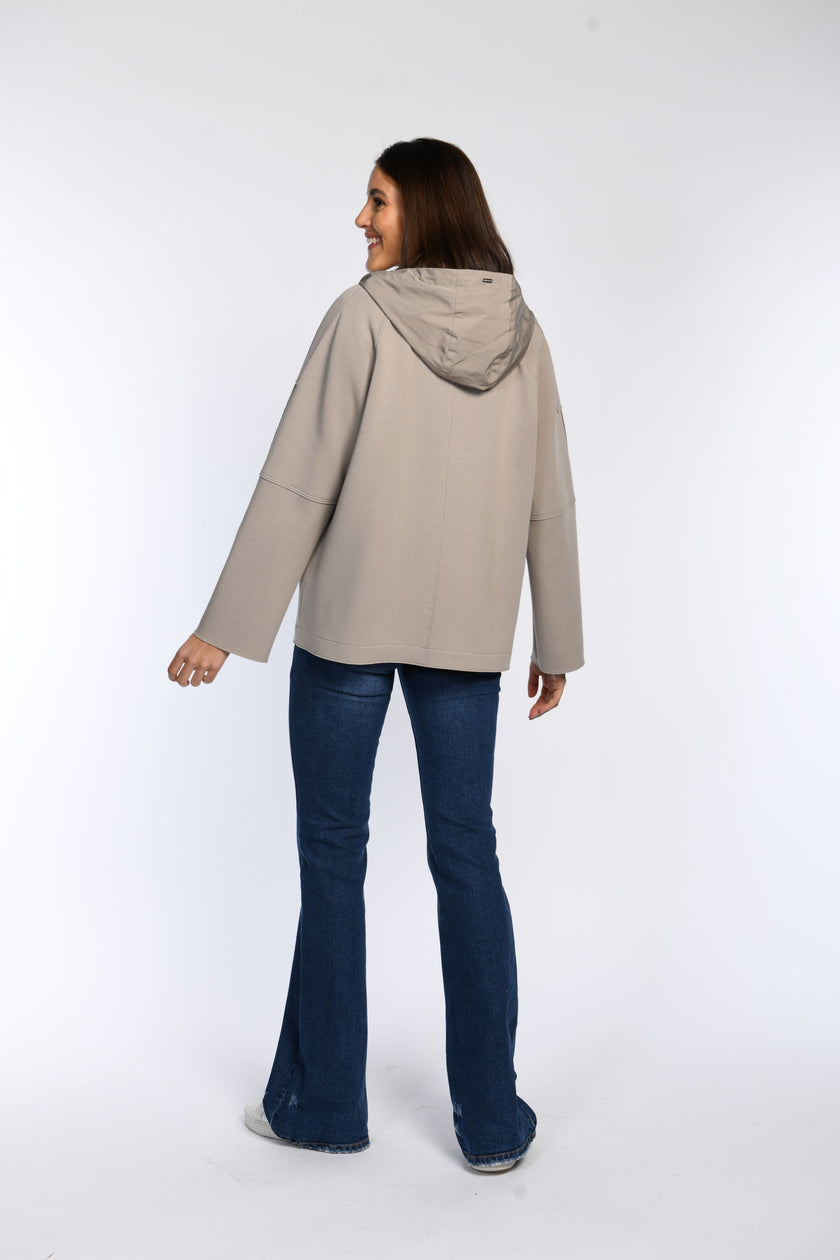 Rückenansicht eines Models in einer taupefarbenen Cabanjacke mit Kapuze.