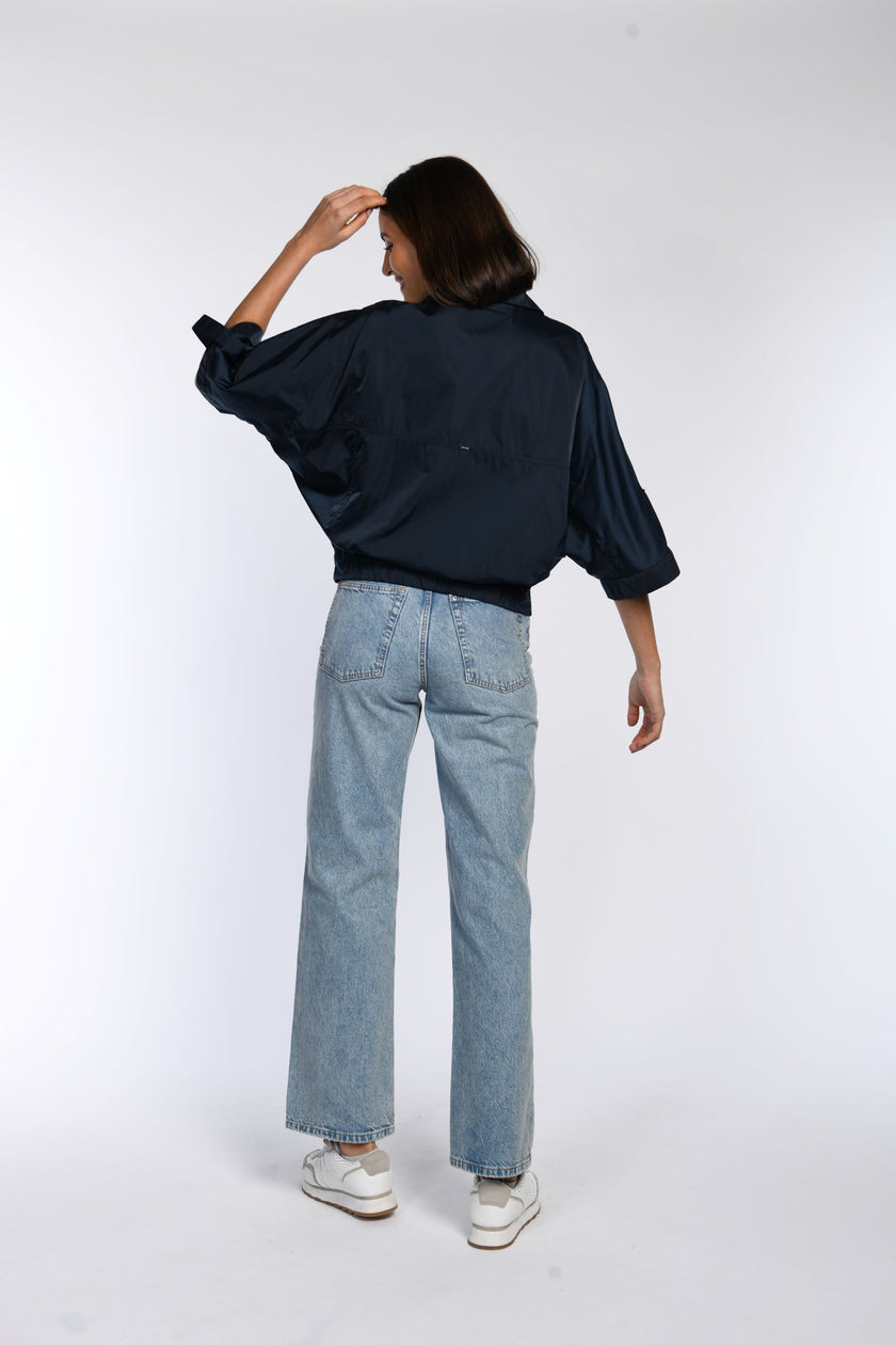 Rückenansicht einer blauen Sommerjacke mit weiten Fledermausärmeln.