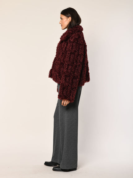 Model trägt gerade geschnittene Jacke aus Webpelz in der Farbe Barolo - Seitenansicht.