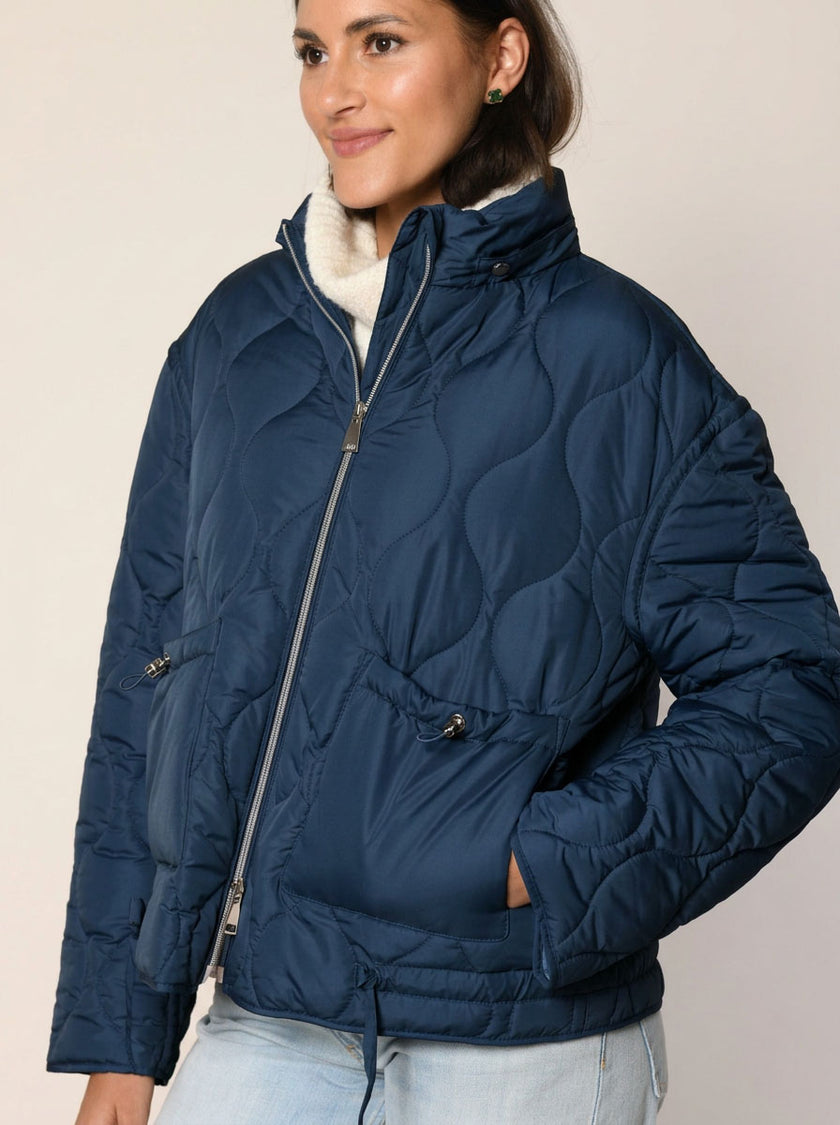 Gerade geschnittene Steppjacke mit Kapuze in der Farbe dunkelblau - Detailansicht.