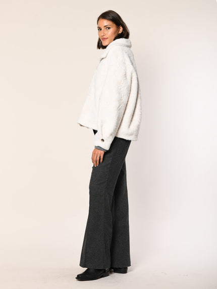 Das Model trägt eine weiße Webpelz Blouson Jacke mit Prägung - Seitenansicht.