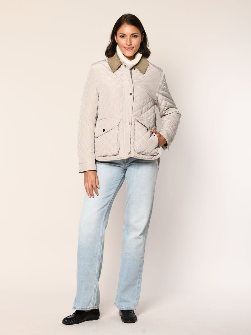 Model trägt gerade geschnittene Steppjacke mit Cordkragen in der Farbe stein - Vorderansicht.