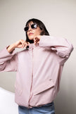 Model trägt geschlossene Oversized-Jacke mit Stehkragen in rosa. 