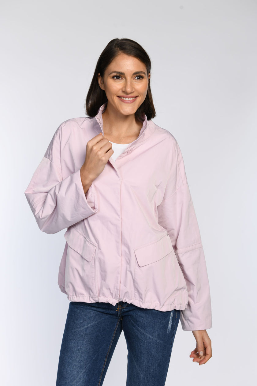 Nahaufnahme: Model trägt eine Oversize-Jacke in Rosa mit Stehkragen und Tunnelzug.