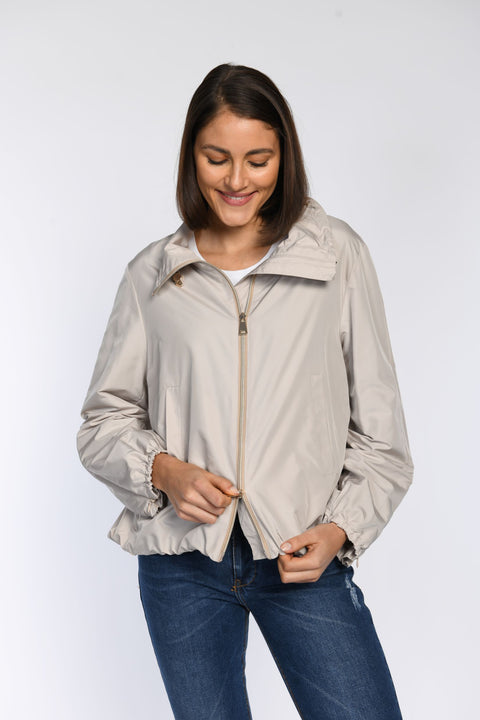 Nahaufnahme: Model trägt beige Sommerjacke mit 2-Wege-Reißverschluss in zartem Goldton.