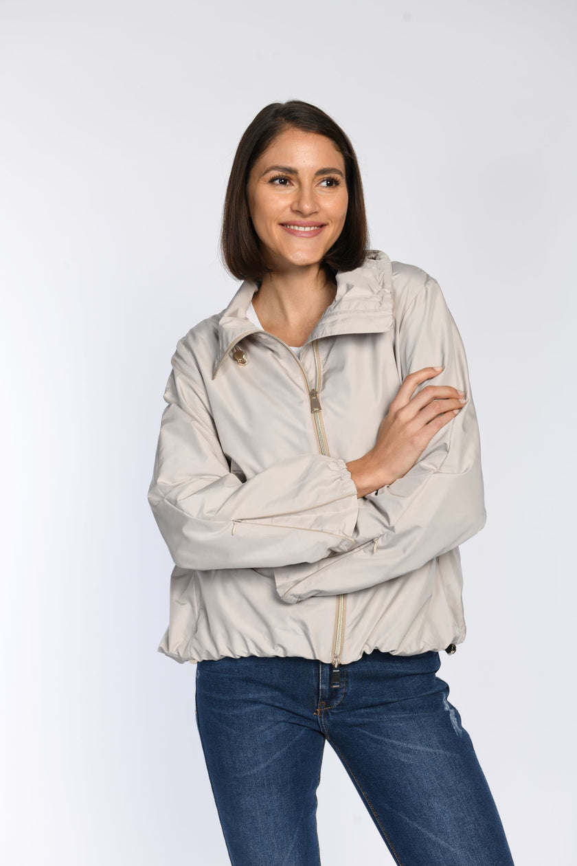 Model trägt geschlossene Sommerjacke mit filigranem Reißverschluss am Ärmelsaum.