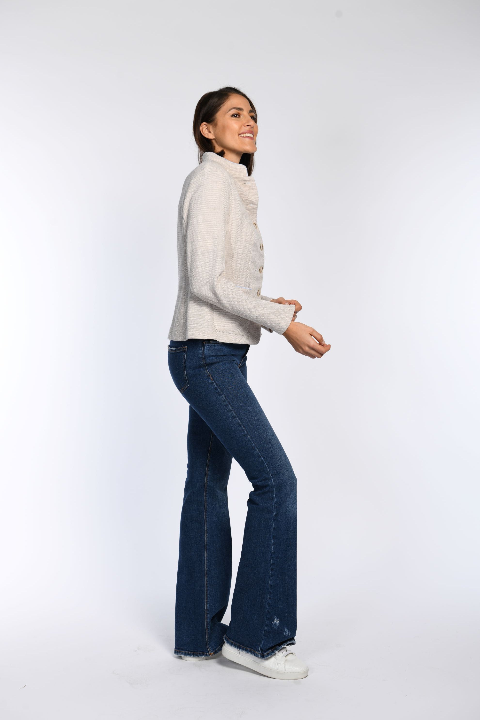 Model trägt langärmligen beigen Janker mit Stehkragen.