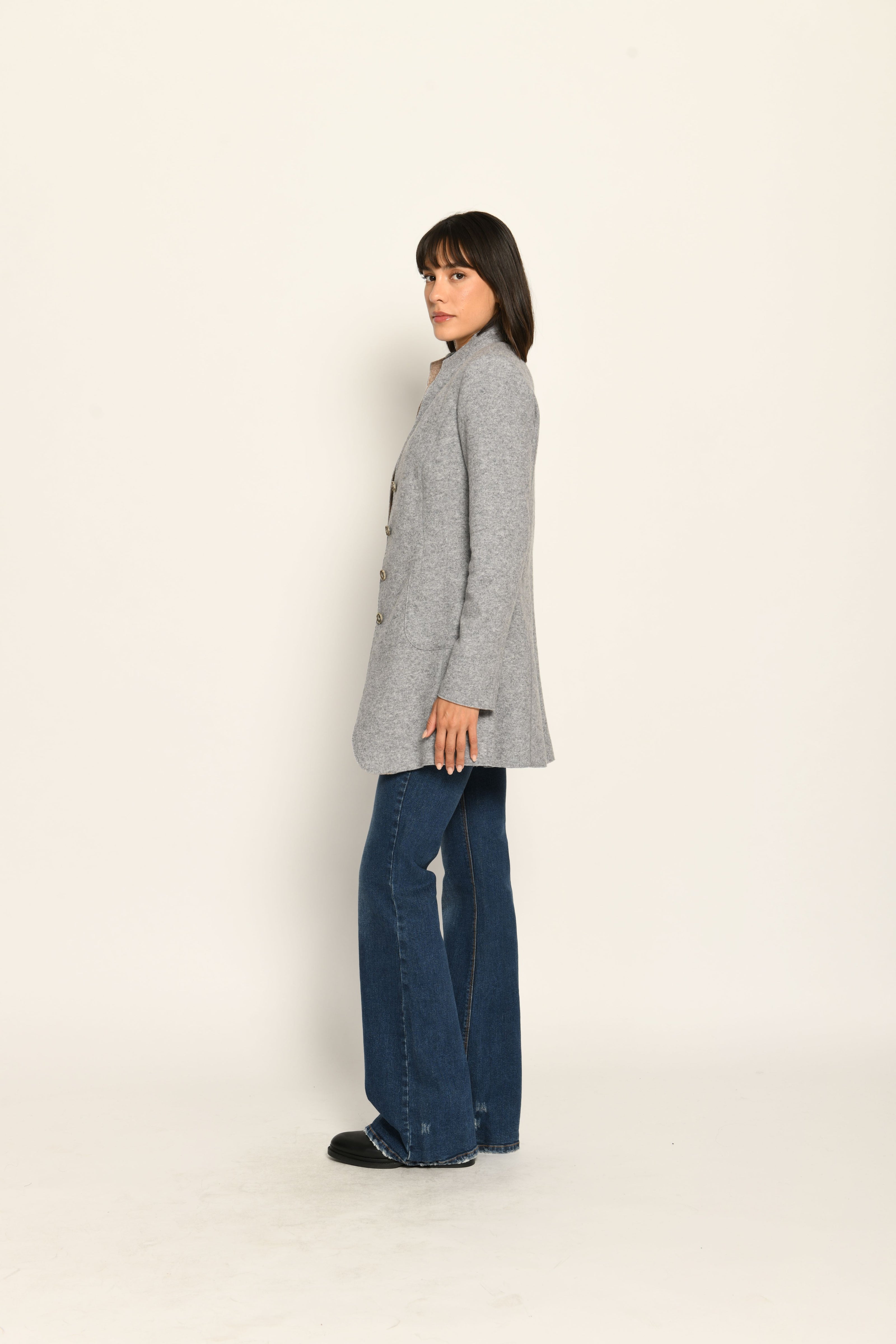 Model trägt grauen Gehrock aus Wolle mit aufgestelltem Kragen, lässig kombiniert zu Jeans – Seitenansicht rechts