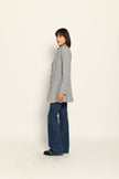Model trägt grauen Gehrock aus Wolle mit aufgestelltem Kragen, lässig kombiniert zu Jeans – Seitenansicht rechts