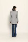 Model trägt grauen taillierten Gehrock aus Wolle mit aufgestelltem Kragen, lässig kombiniert zu Jeans – Rückansicht