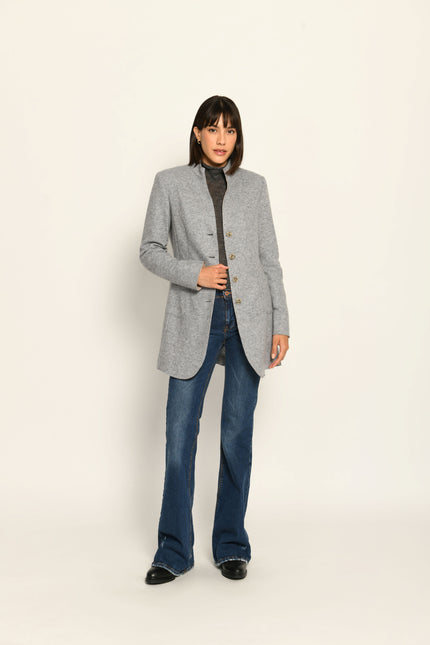 Model trägt grauen Gehrock mit offener Knopfleiste und aufgestelltem Kragen – stehende Pose, Blick nach vorne