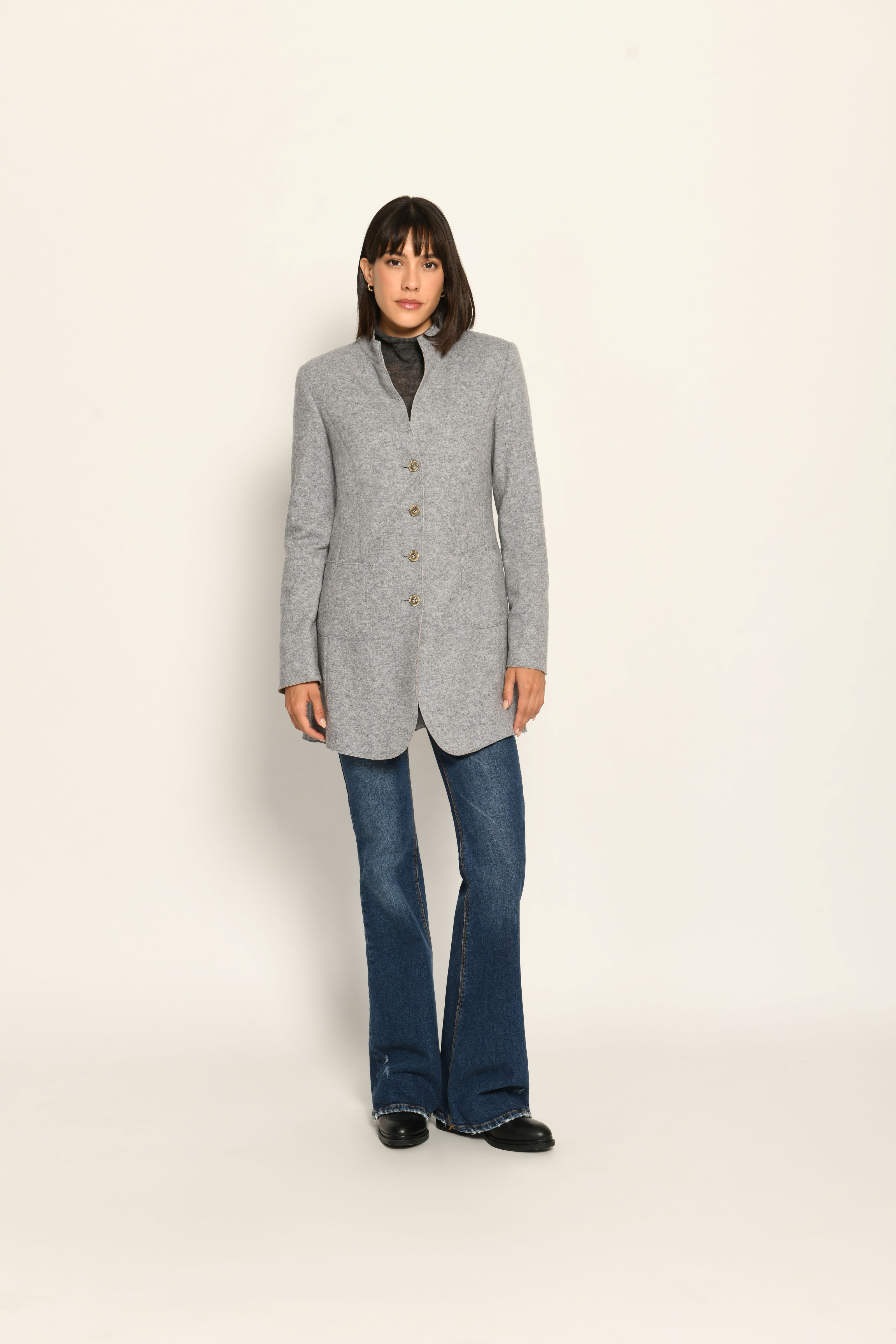 Model trägt grauen Gehrock mit geschlossener Knopfleiste und aufgestelltem Kragen – stehende Pose, Vorderansicht