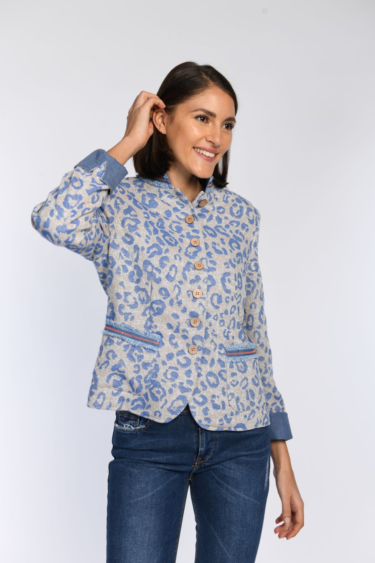 Model trägt einen tailiiert geschnittenen, langärmligen grünen Janker mit blauem jeansigem Leo-Print.