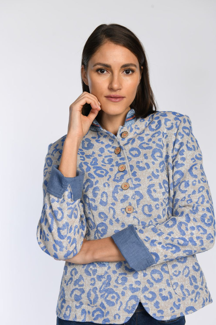 Nahaufnahme eines beigefarbenen Jankers mit blauem Leopardenprint und umgeschlagenen Ärmeln.